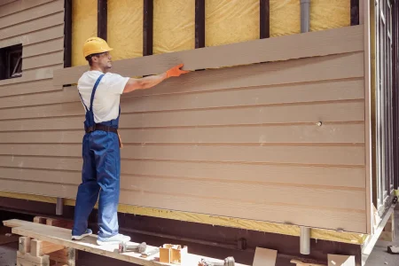 handsome-man-builder-building-cabin-construction-site